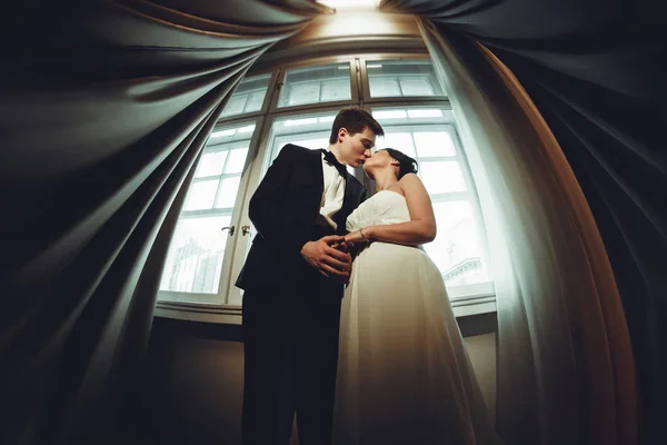 Ein Blick von unten auf ein küssendes Hochzeitspaar, das zwischen — Stockfoto