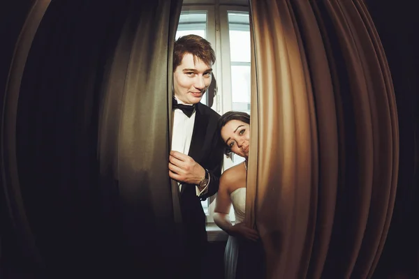 Komedia nowożeńcy stoją za beig zasłony — Zdjęcie stockowe