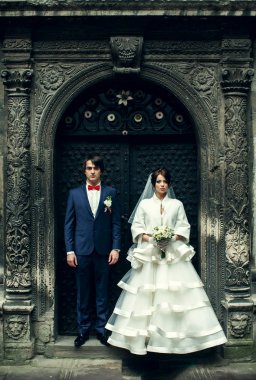 Gelin ve damat düz bir eski çelik kapının arkasında durmak 