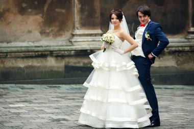 Gelin ve damat onların waists üzerinde yan yana elele standı