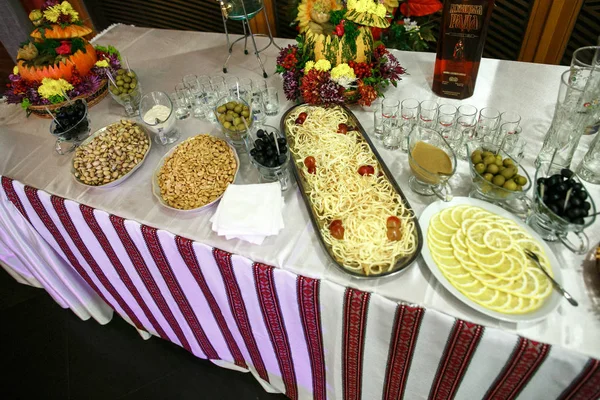 Tavolo con gustosi antipasti ricoperti con panno etnico — Foto Stock
