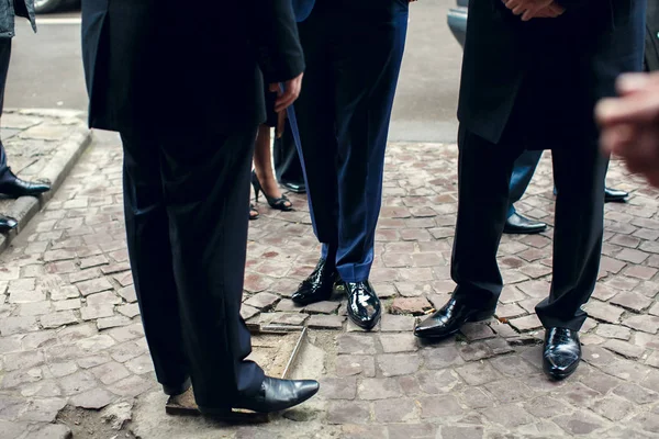 Hombres con trajes parados en el pavimento al aire libre —  Fotos de Stock