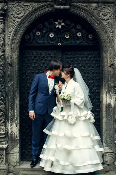 Vőlegény hajlik a menyasszony mögött egy acél ajtó — Stock Fotó