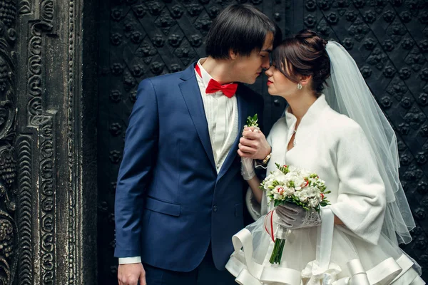 Groom tient la main de la mariée derrière sa poitrine debout quelque part dans — Photo