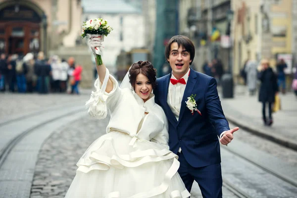 Nowożeńcy zabawny uśmiech stojący między sposobami tramwaj na miasto — Zdjęcie stockowe