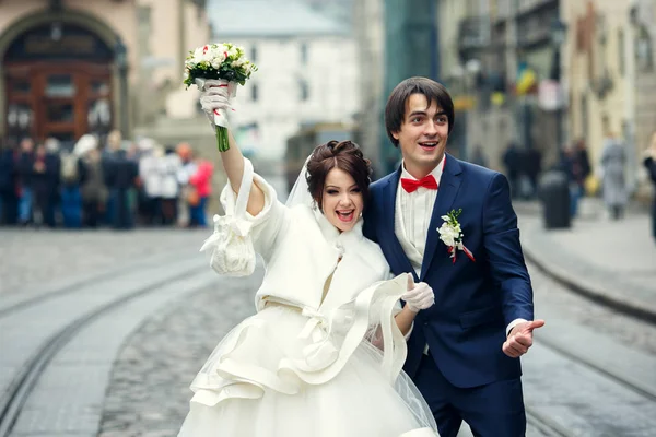 Жених и невеста выглядят забавно, позируя на старой городской площади — стоковое фото