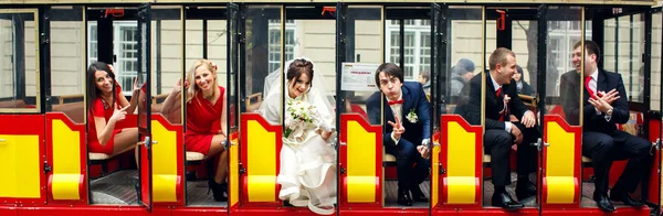 Jonggehuwden en vrienden zitten in de deuren van een liitle tram — Stockfoto