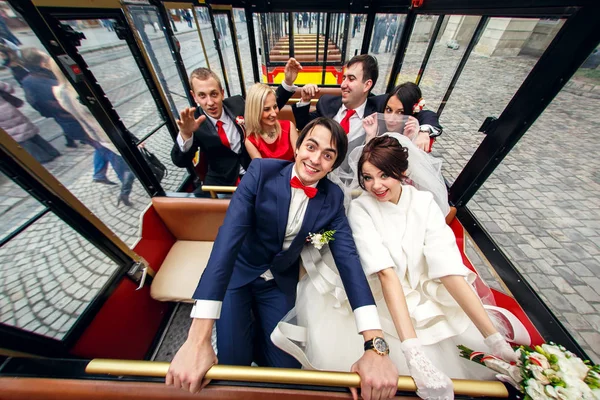 婚礼夫妇微笑坐在观光列车的朋友 — 图库照片
