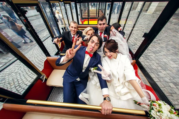 Śmieszni ludzie siedzą w autobus turystyczny wraz z nowożeńcy — Zdjęcie stockowe