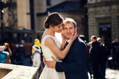 Güzel gelin damat'ın yüz deilcate ellerini tutar. 