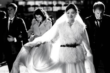 Arkadaşlar ve damat ile gelini bir furcoat yürür 