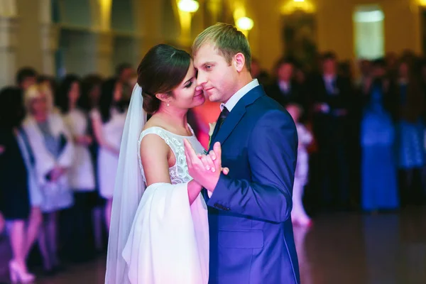 Mariée se penche vers un marié dansant avec lui dans une salle fou de gens — Photo