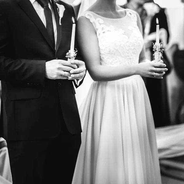 Stylish wedding couple stand with white burning candles in the c — Stock Photo, Image