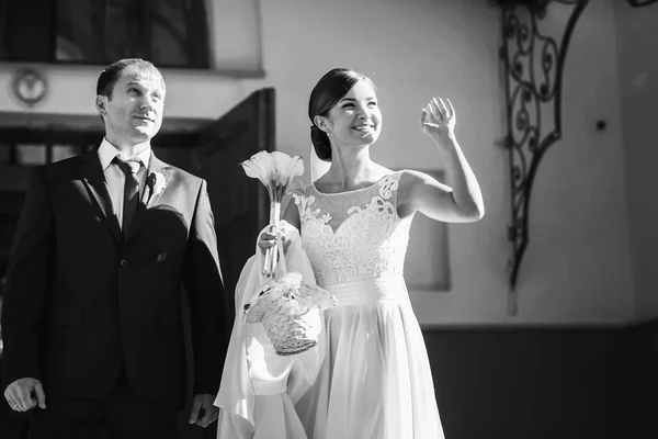 Жених и невеста стоят в лучах солнца за входом — стоковое фото