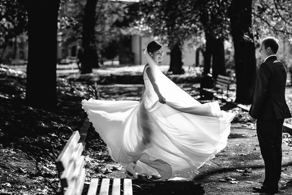 Silhouette einer wirbelnden Braut, die von einem Bräutigam bewundert wird — Stockfoto