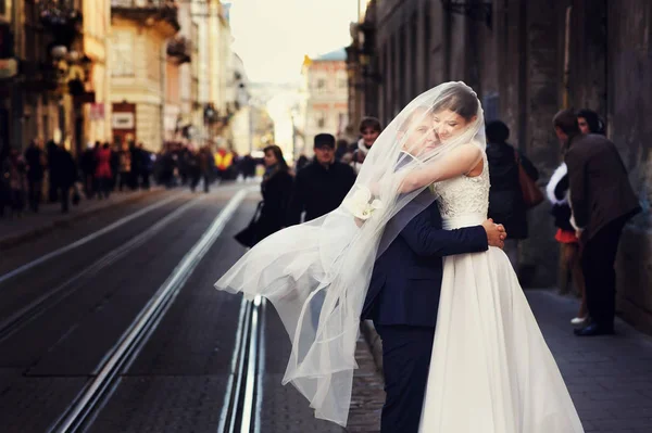 Mariée étreint un marié caché sous son voile — Photo