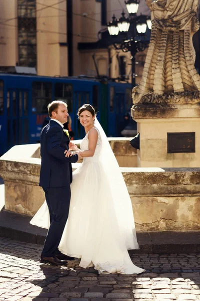 Sposo tiene per mano di sposa sorridente mentre si trovano dietro un ol — Foto Stock