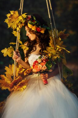 Gelin salıncakta oturan çarpıcı görünüyor tam sonbahar çiçek