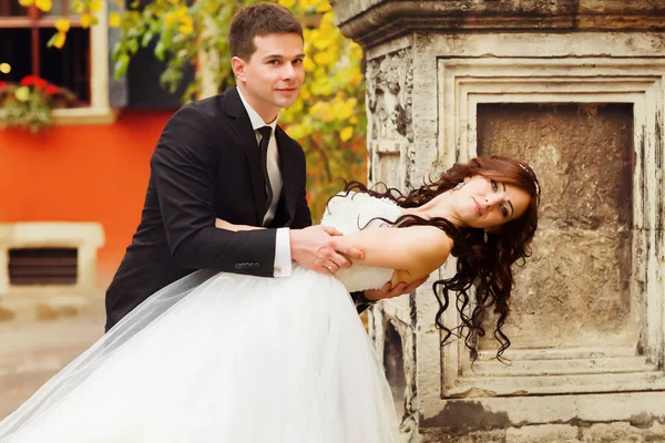 Sposo curve bruna sposa oltre in piedi dietro un vecchio pilastro — Foto Stock