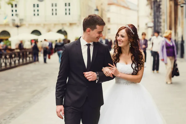 Groom leva uma noiva ao longo da rua segurando sua mão — Fotografia de Stock