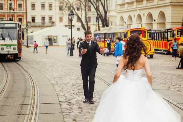 Жених просит невесту подойти к нему, пока он стоит между трамваем — стоковое фото
