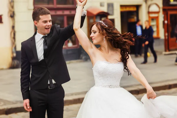 Наречена кружляє навколо руки нареченого на міській площі — стокове фото