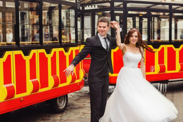 Щаслива весільна пара танцює за туристичним автобусом — стокове фото