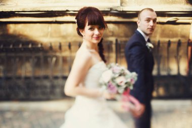 Güzel gelin damat ile yürüyüş onun omuz üzerinde görünüyor 