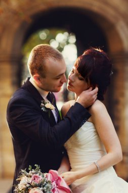 Damat bir gelin için eğilir ve yüzünü bir öpücük önce dokunur 