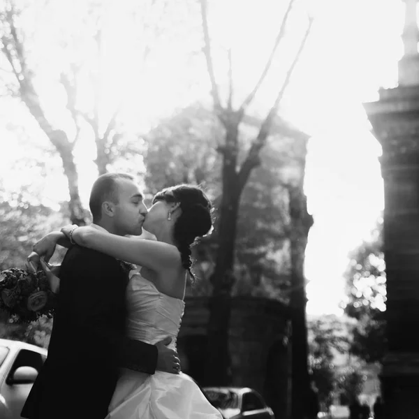Una imagen en blanco y negro de los recién casados besándose en algún lugar de la — Foto de Stock
