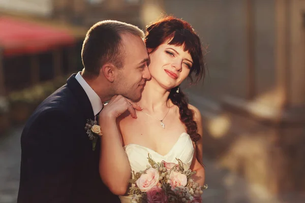 Sposo tocca collo delicato della sposa con il naso mentre essi pos — Foto Stock