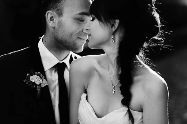 Uma imagem em preto e branco de um noivo deslumbrante segurando um b concurso — Fotografia de Stock