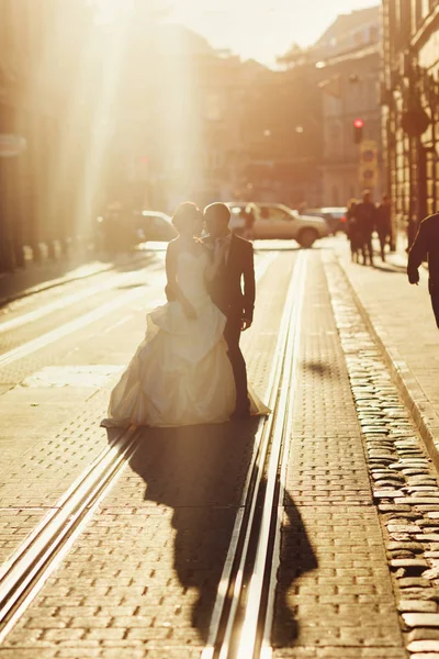 Raios solares escondem os recém-casados em pé nos bondes — Fotografia de Stock