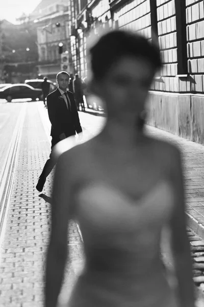 A blurred picture of a bride while groom folows her along the st — Stock Photo, Image