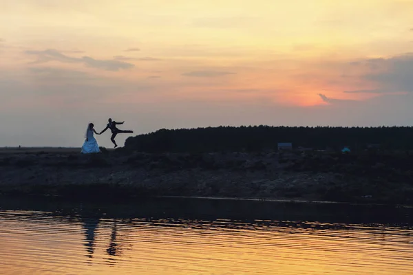 Günbatımı bir gelin atlama bir damat aydınlatır — Stok fotoğraf