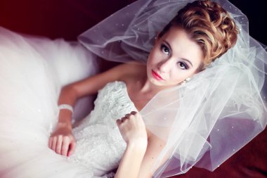 Gelin büyük sandalyede oturan provoke bir şekilde görünüyor