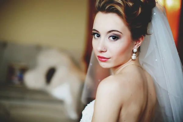 Hübsche Braut mit roten Lippen blickt über ihre Schulter — Stockfoto