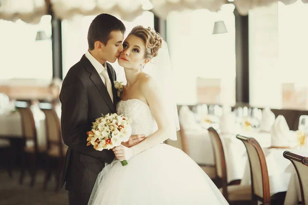 Bride looks up while groom kisses tender her cheek — Stock Photo, Image