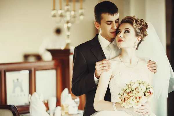 Jolie mariée regarde un marié pendant qu'il se tient derrière elle — Photo