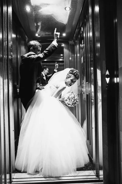 Noiva desce diante de um noivo de pé no elevador — Fotografia de Stock