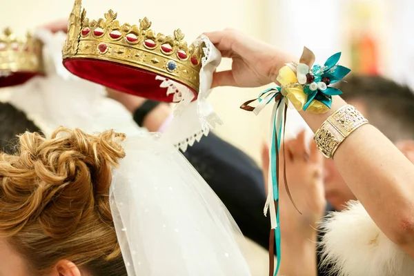 Mão dama de honra decorada com pulseira de flores detém uma coroa ov — Fotografia de Stock