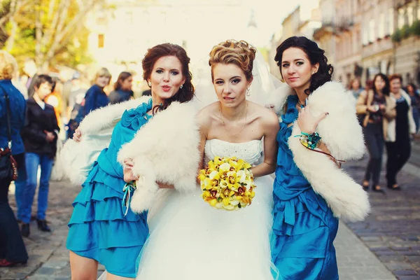 Noiva morde os lábios posando com damas de honra engraçadas na rua — Fotografia de Stock