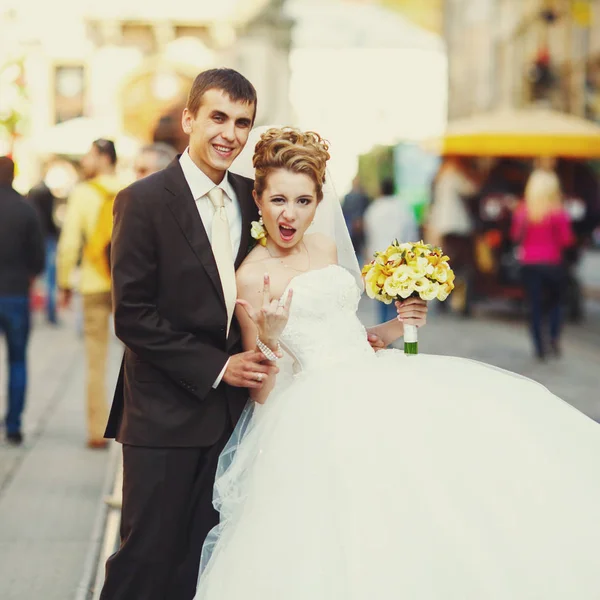 Chaussures de mariée un signe de rock'n'roll posant avec un marié sur le vieux — Photo