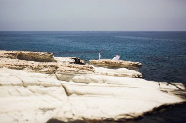 Uzaktan bir gelin elbisesini taş denize yayılan bir görünüm
