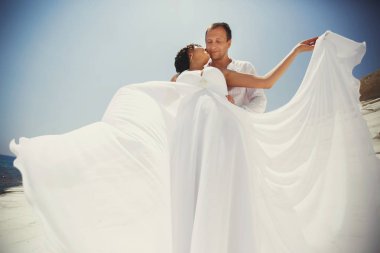 Deniz kıyısında poz arkasından çarpıcı bir gelin damat hugs 