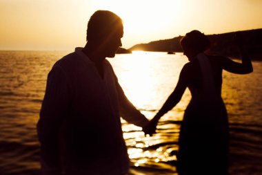 Bir kaç gün batımı için suda yürüme siluetleri