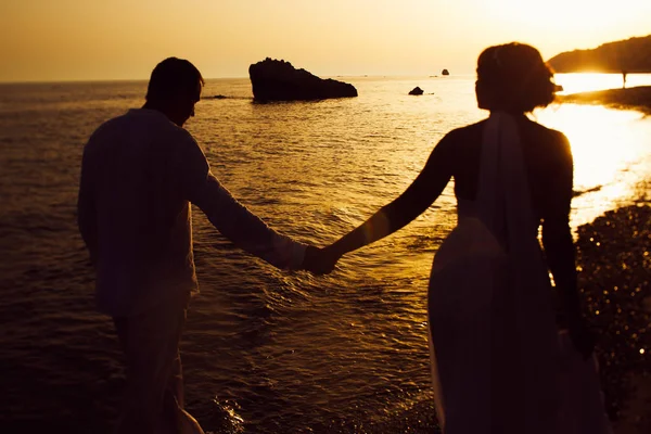 Novia y novio enjoya momento caminando a lo largo de la orilla del mar — Foto de Stock