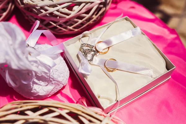 Ricos anillos de oro de la boda se encuentran en las cintas blancas en una plata b — Foto de Stock