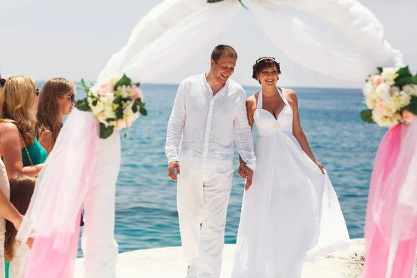 お客様を迎える新婚夫婦の海のそばに立って — ストック写真