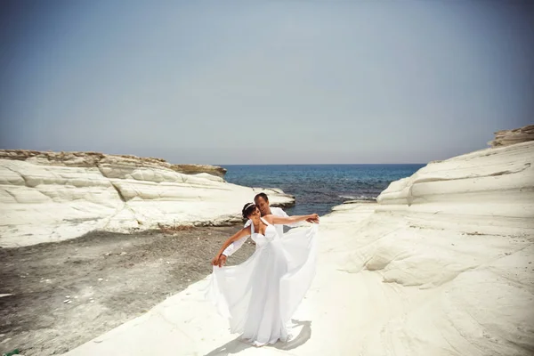 入札新婚ポーズ明るい夏の下で白い石海岸 — ストック写真